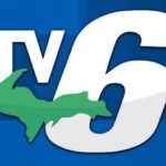 white TV6 with green outline of Upper Peninsula on Blue Background